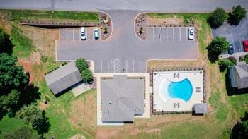 arial view of a parking lot with a swimming pool and a driveway